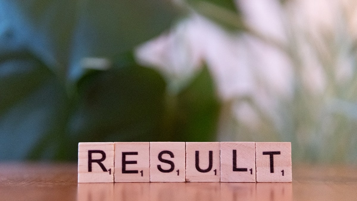 A wooden block spelling the word result on a table